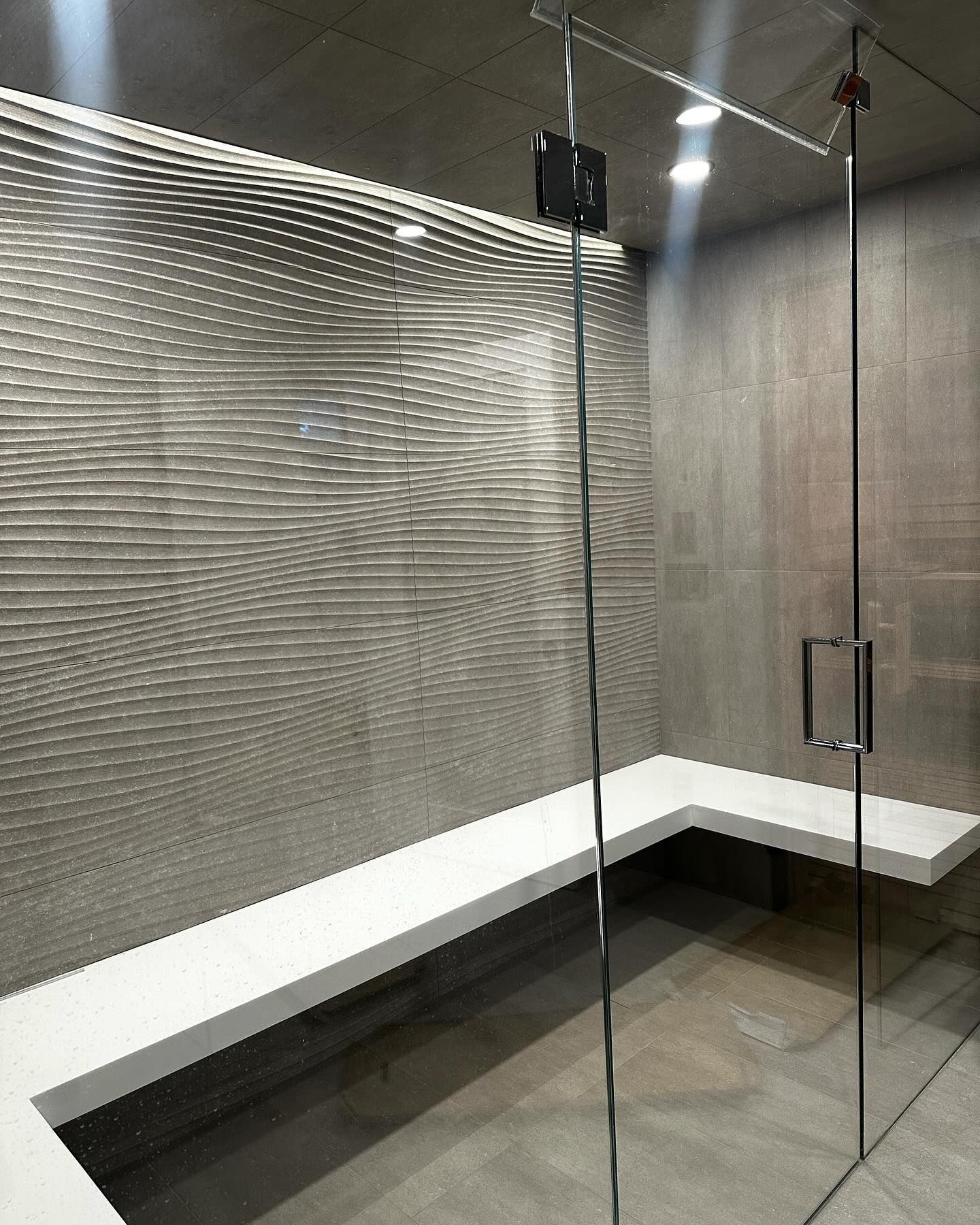 a bathroom with a bench and a glass door