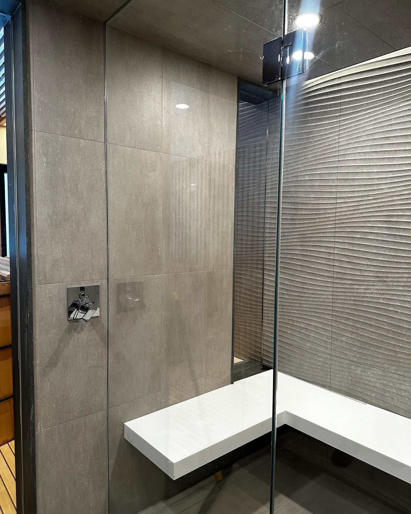a bathroom with a walk in shower and a bench