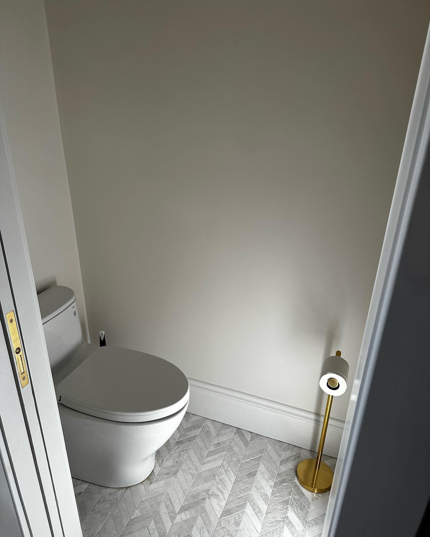 a bathroom with a toilet and a roll of toilet paper