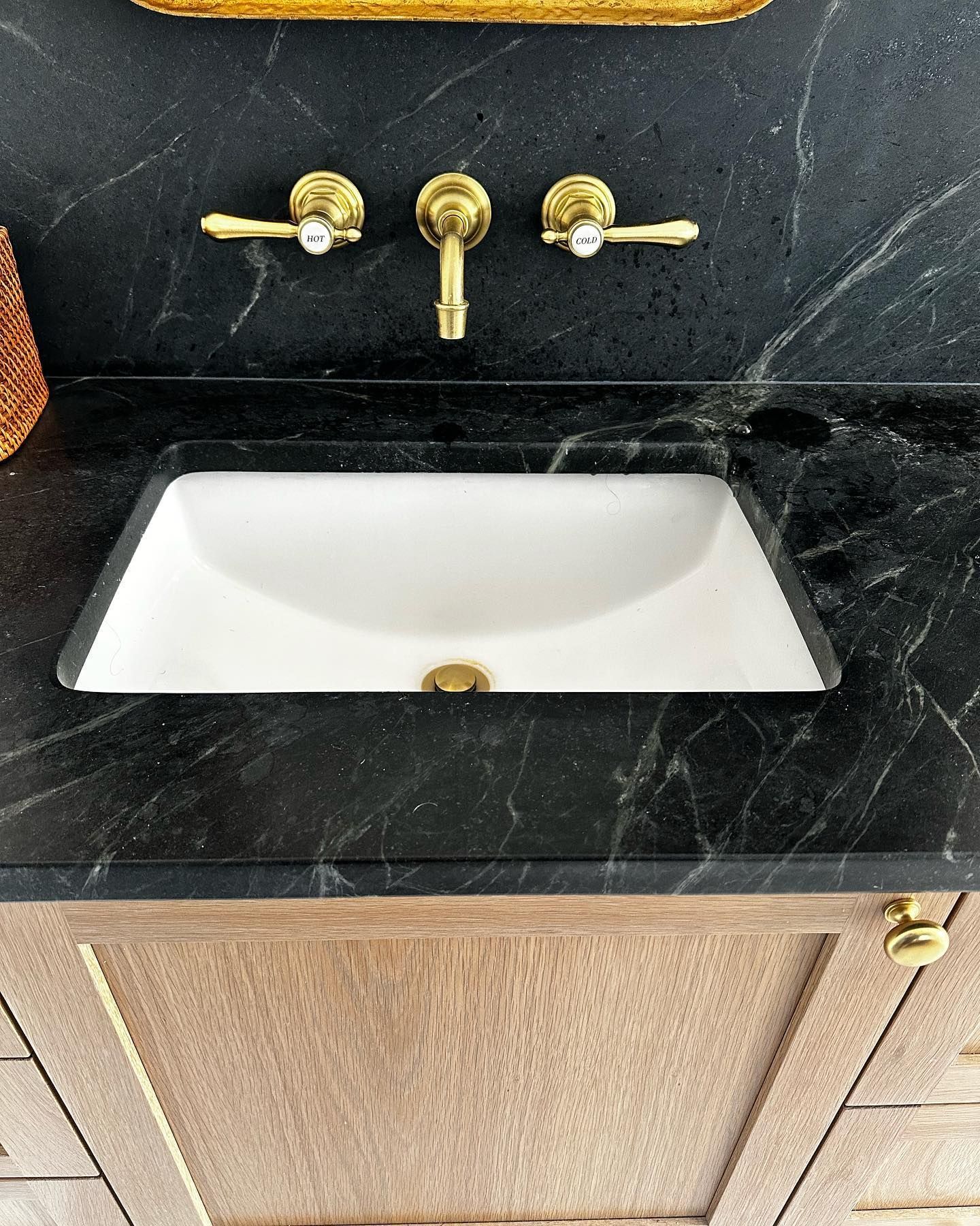 a bathroom sink with a black marble counter top