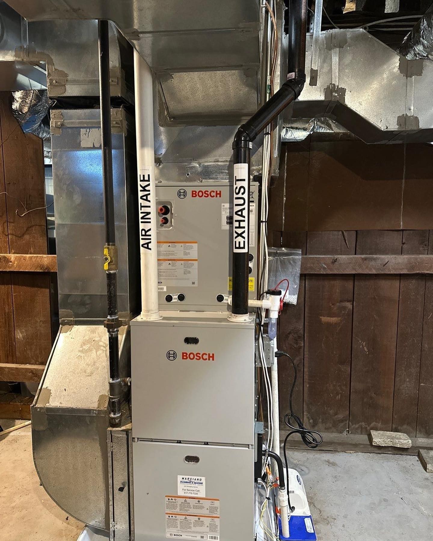 a Bosch air conditioner is sitting in a basement next to a wooden wall