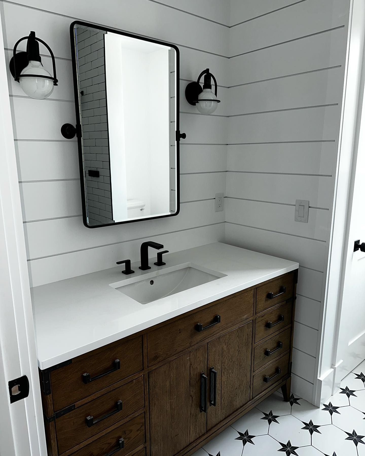 a bathroom with a sink, mirror and drawers