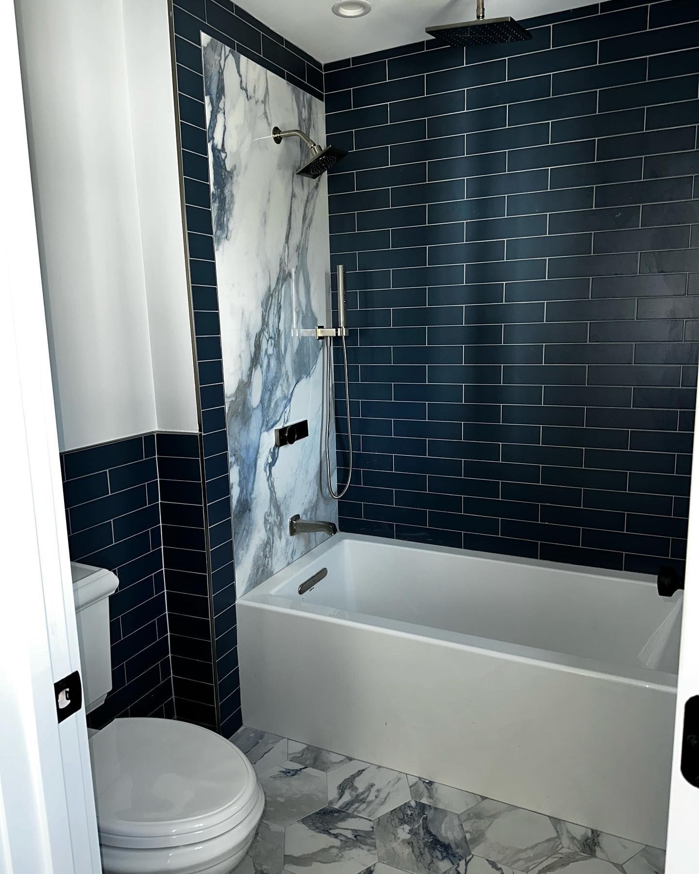 a bathroom with a toilet, bathtub and shower