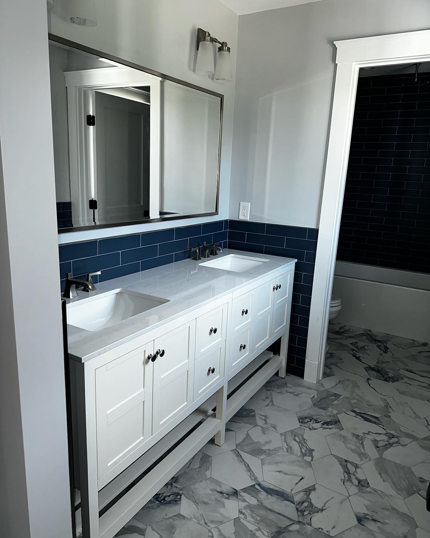 a bathroom with two sinks, a mirror and a bathtub