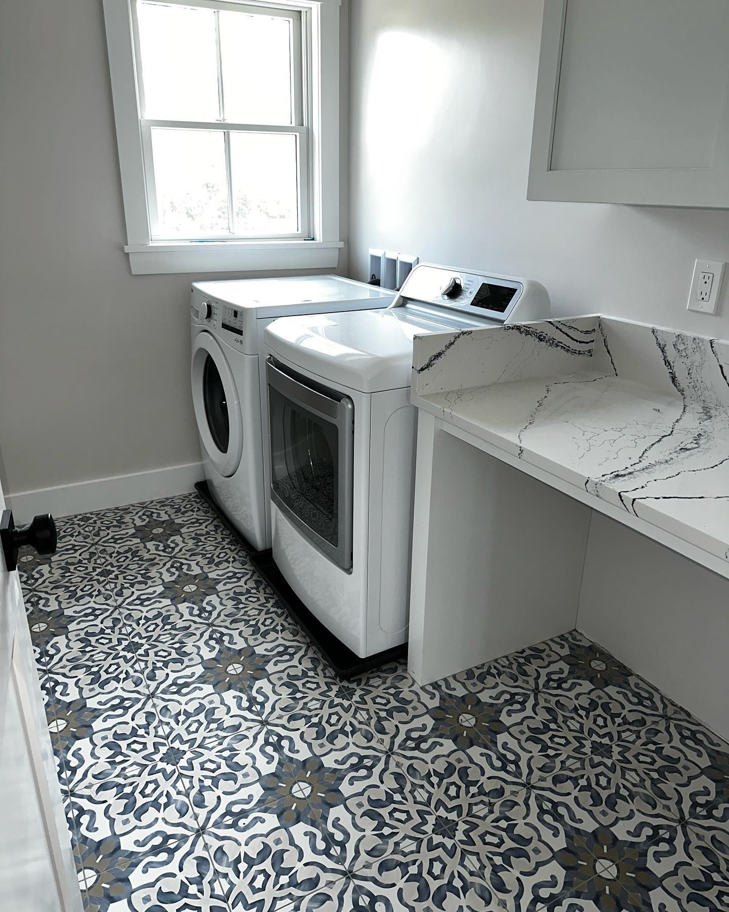 a laundry room with a washer and dryer and a window