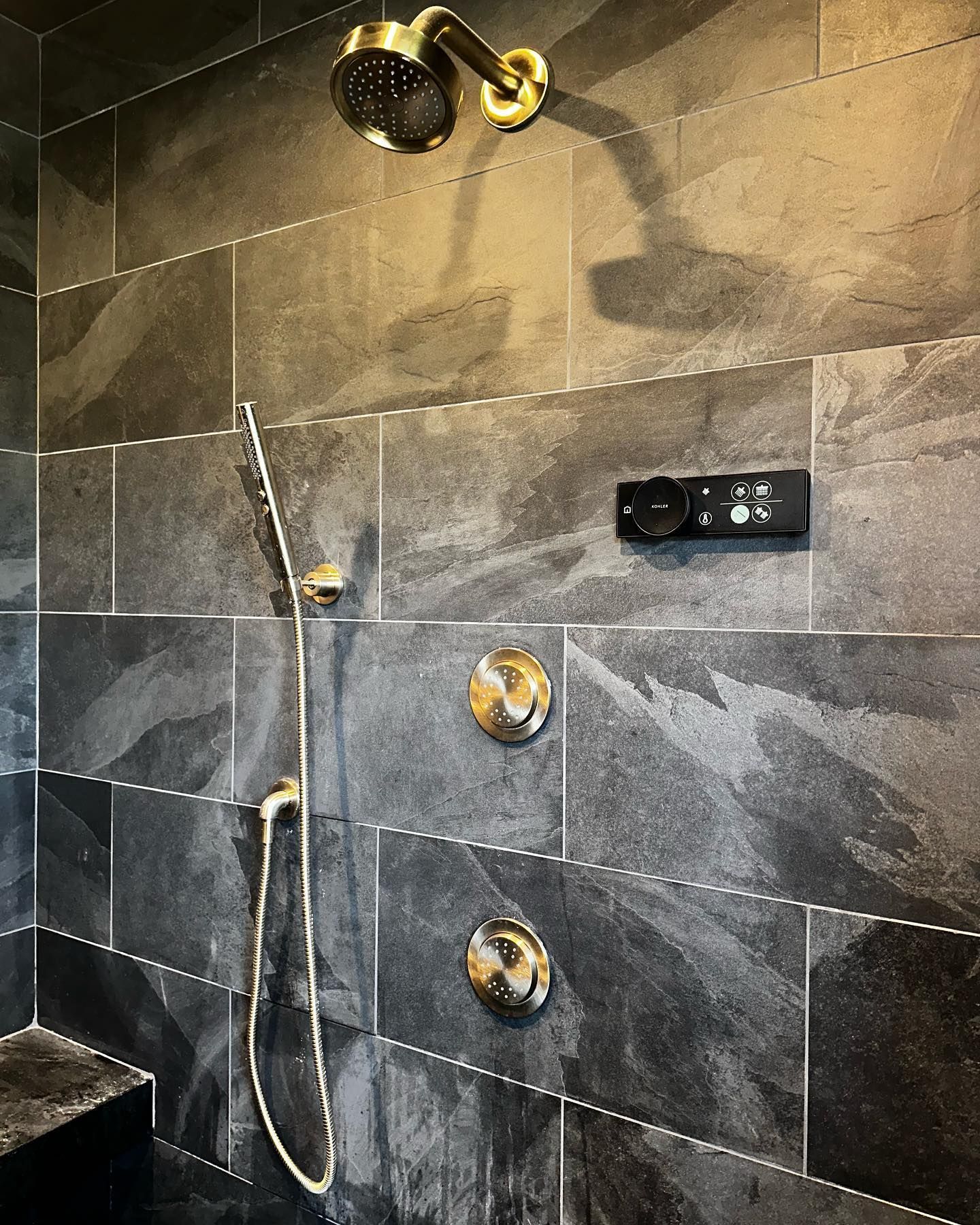 a shower head is hanging on a tiled wall in a bathroom