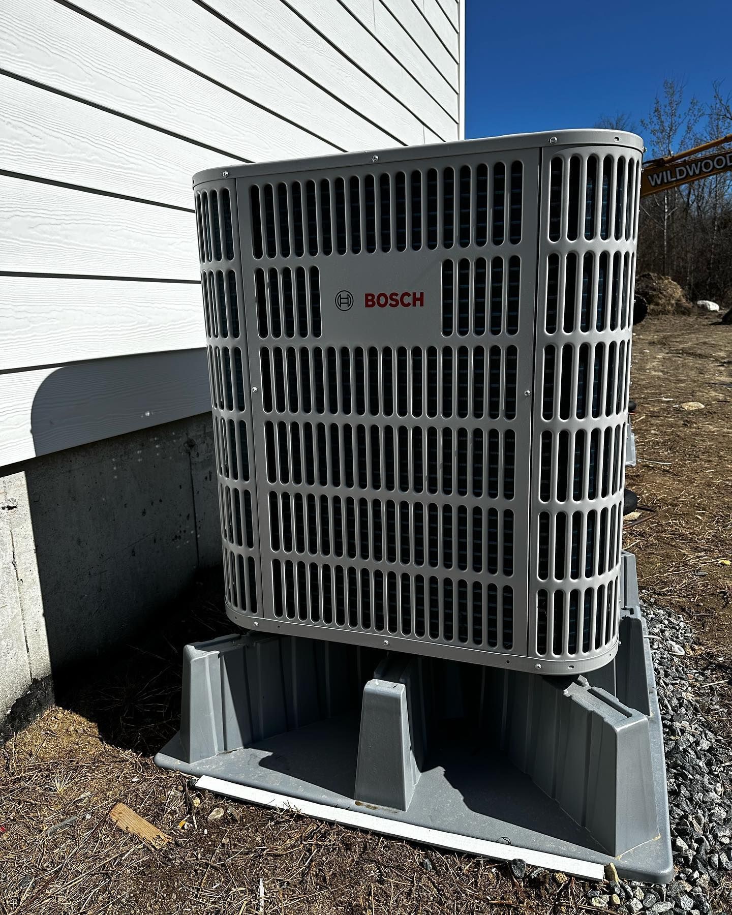 a Bosch air conditioner is sitting on the side of a house