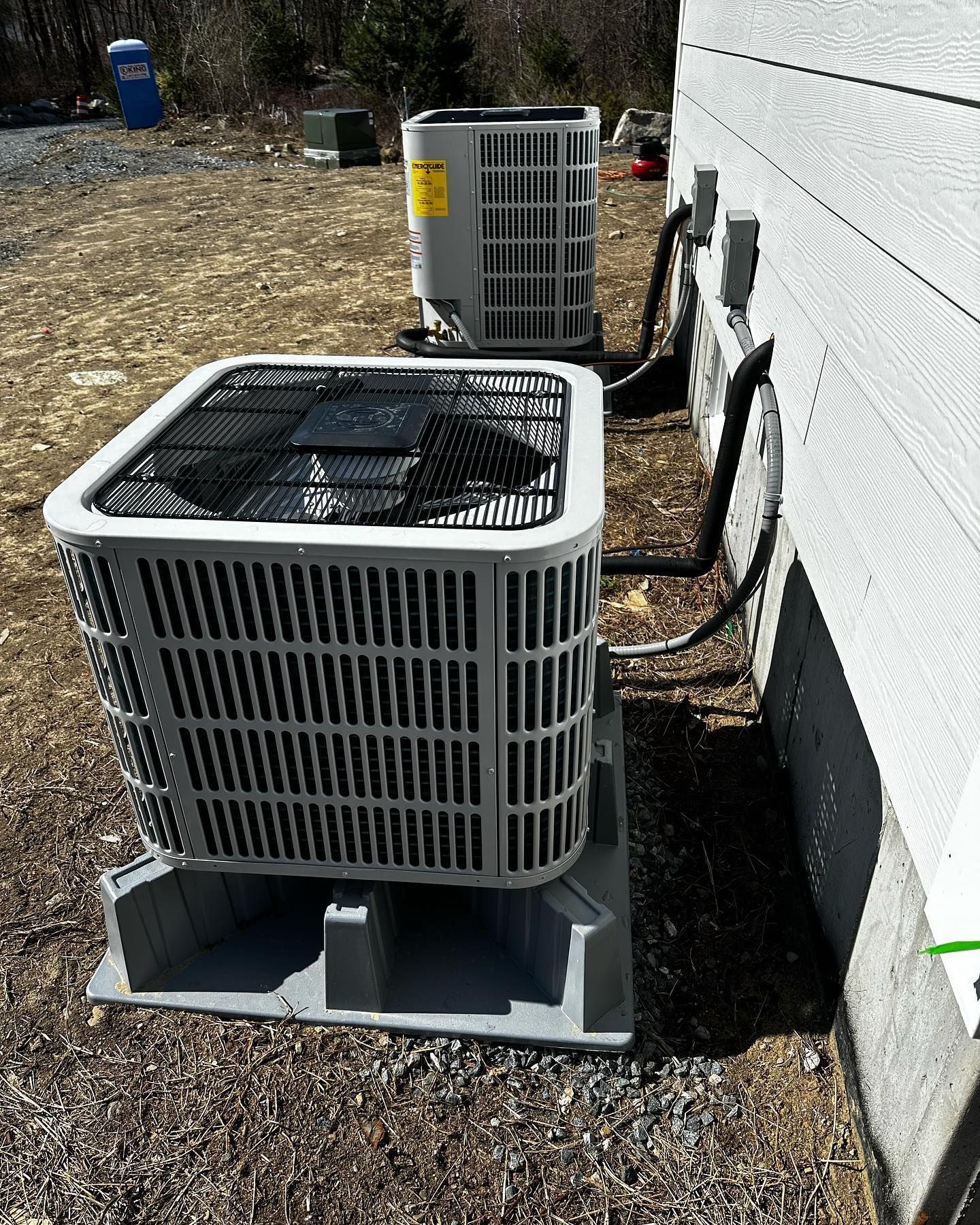 two air conditioners are sitting next to each other on the side of a building