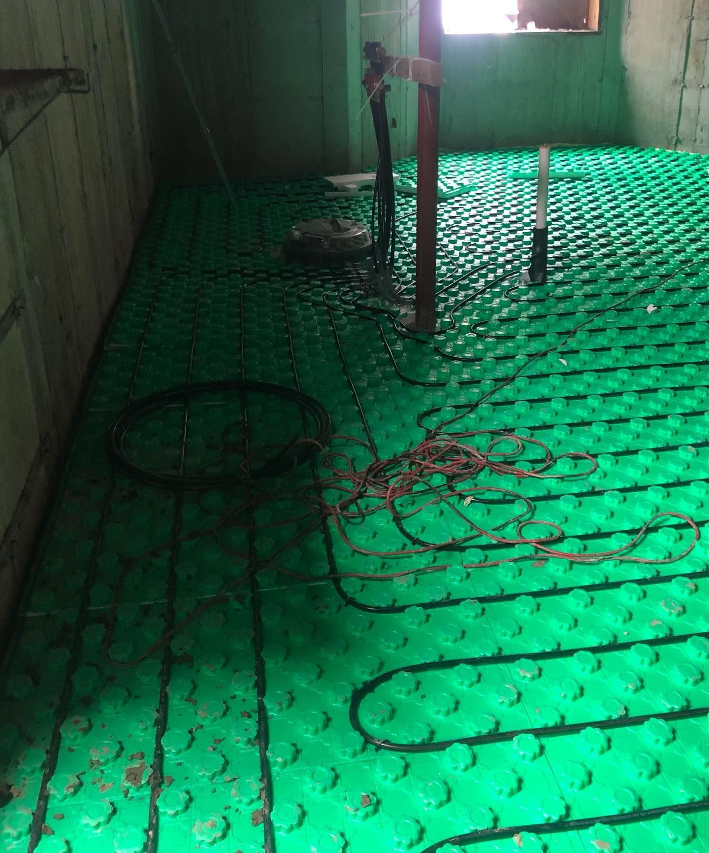 a green underfloor heating system is being installed in a room