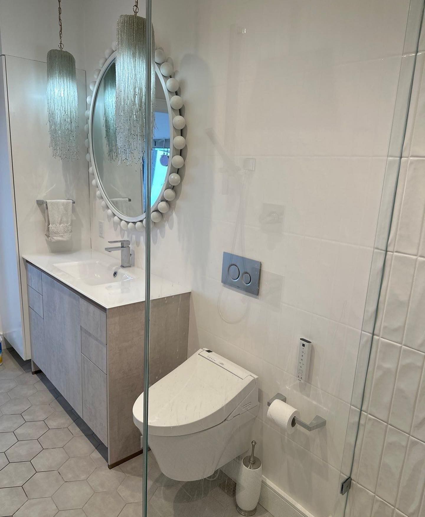a bathroom with a toilet, sink, mirror and shower