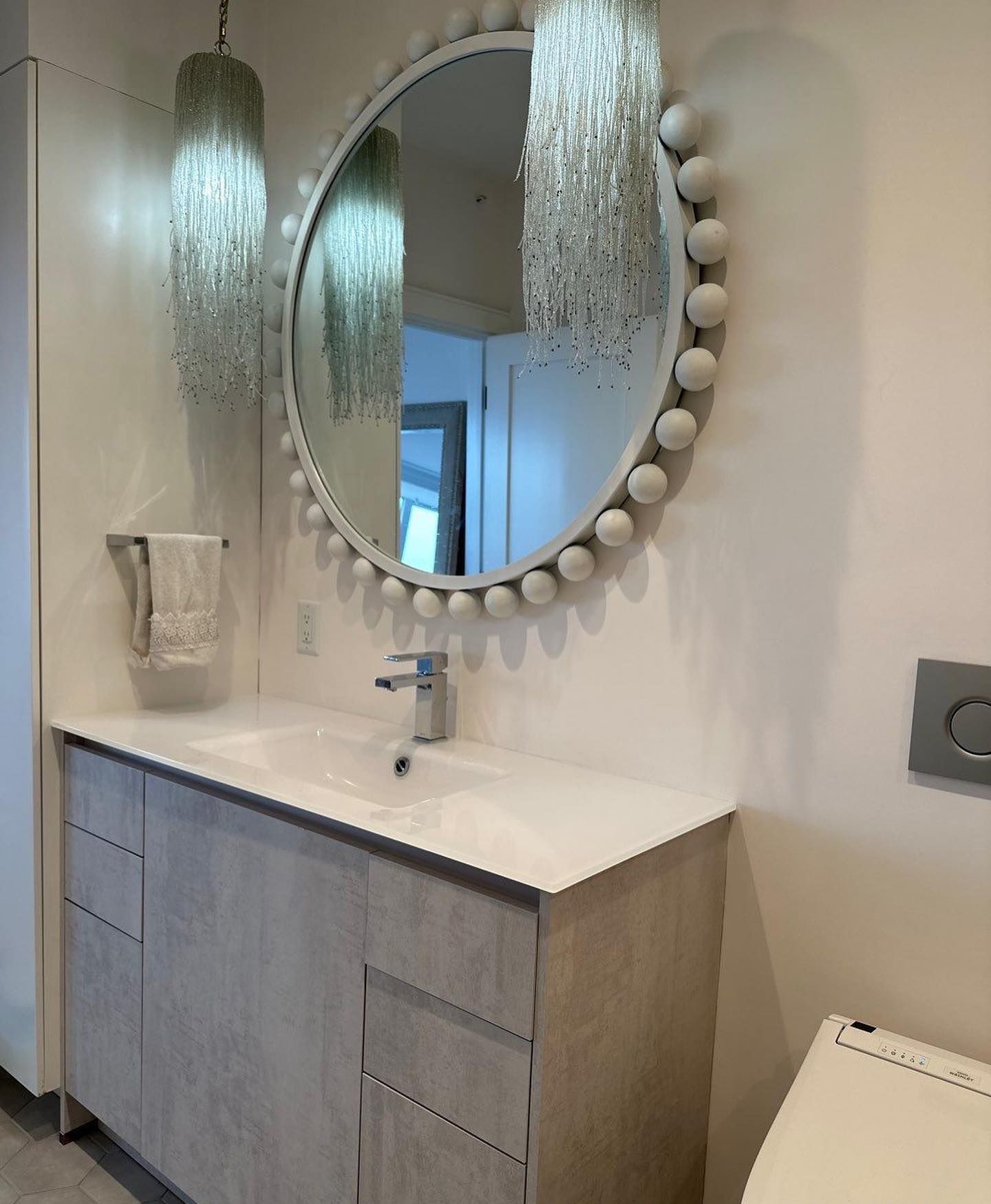 a bathroom with a sink and a round mirror