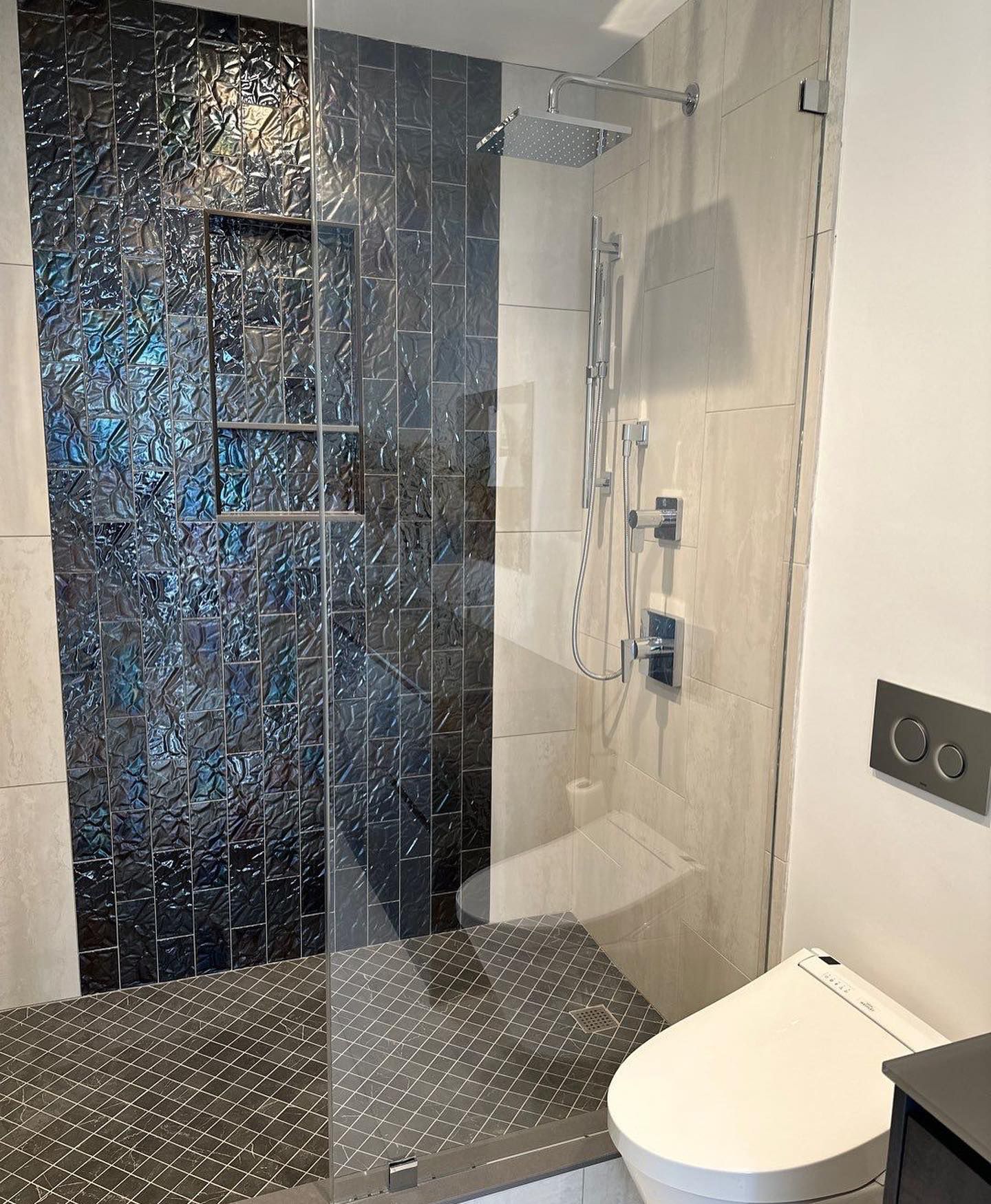 a bathroom with a toilet and a shower with a glass door
