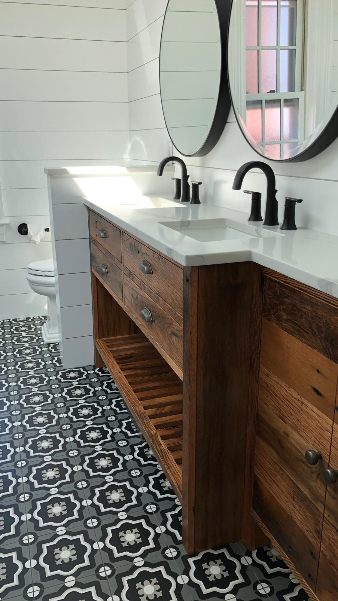 a bathroom with two sinks, two mirrors and a toilet