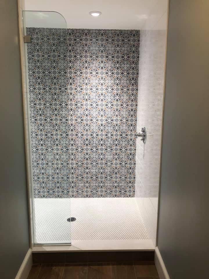 a bathroom with a walk in shower and a glass door