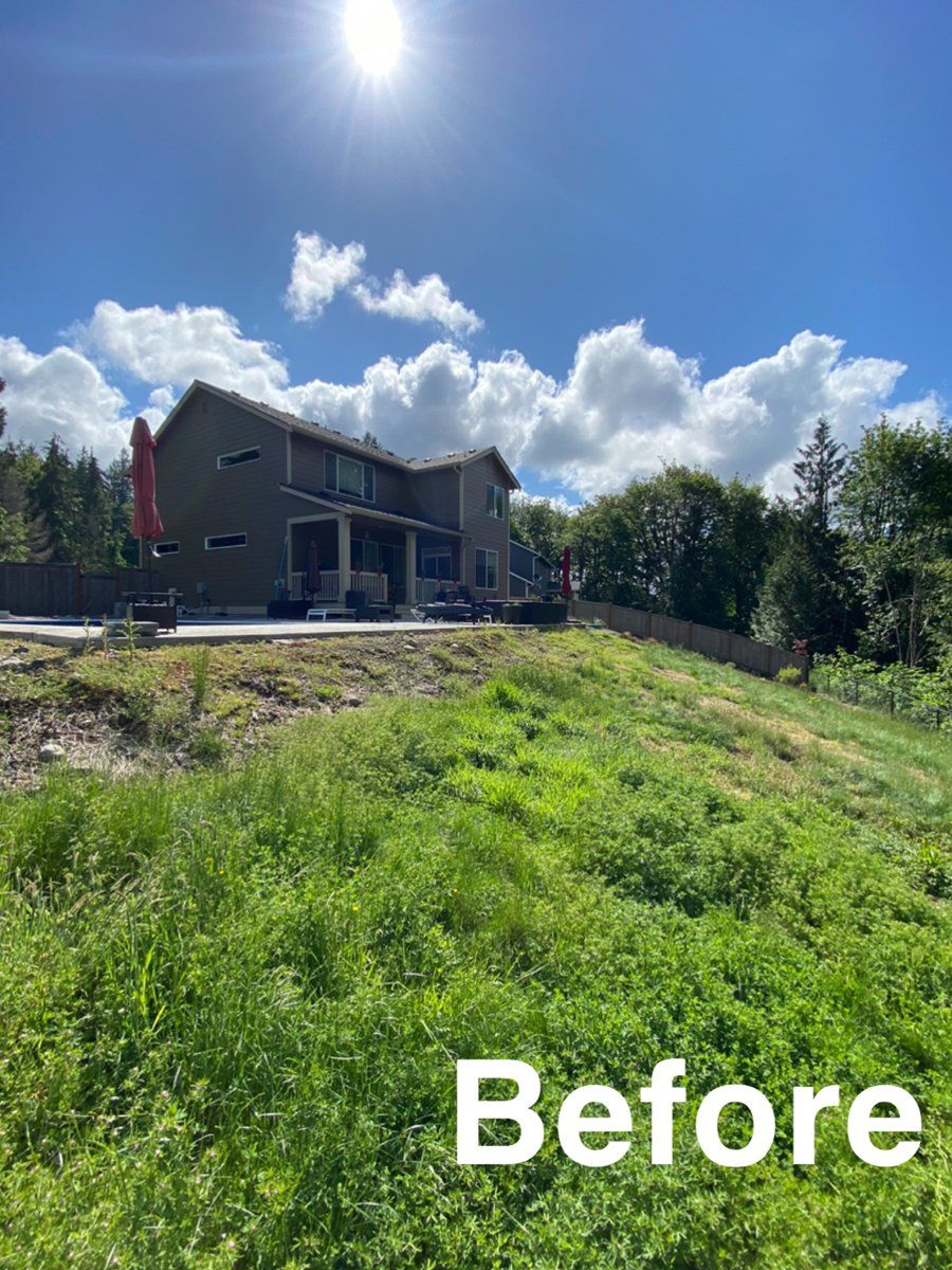 A large house is sitting on top of a grassy hill.