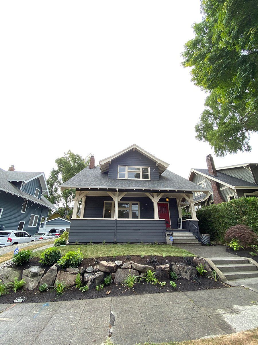 A small house with a porch and a red door