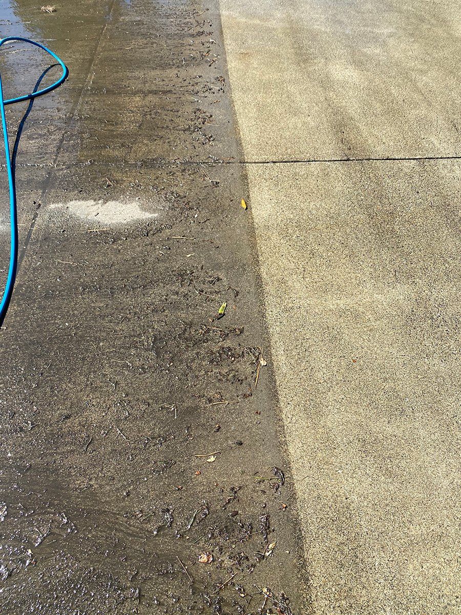 A hose is being used to clean a concrete floor.