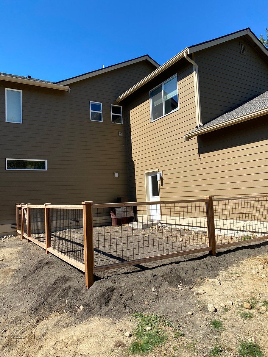 A house with a wooden fence in front of it.