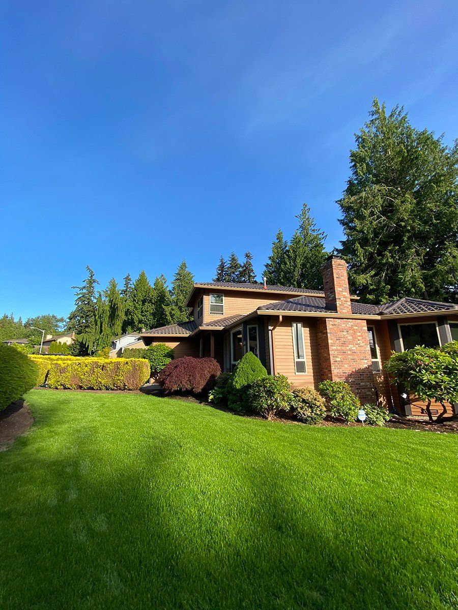 A brick house with a large lawn in front of it