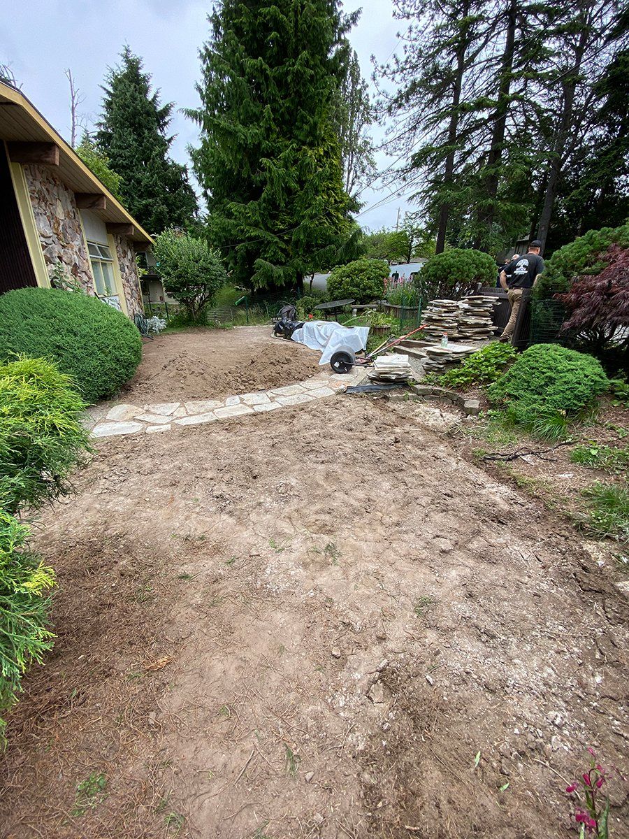 A dirt path leading to a house in a garden.