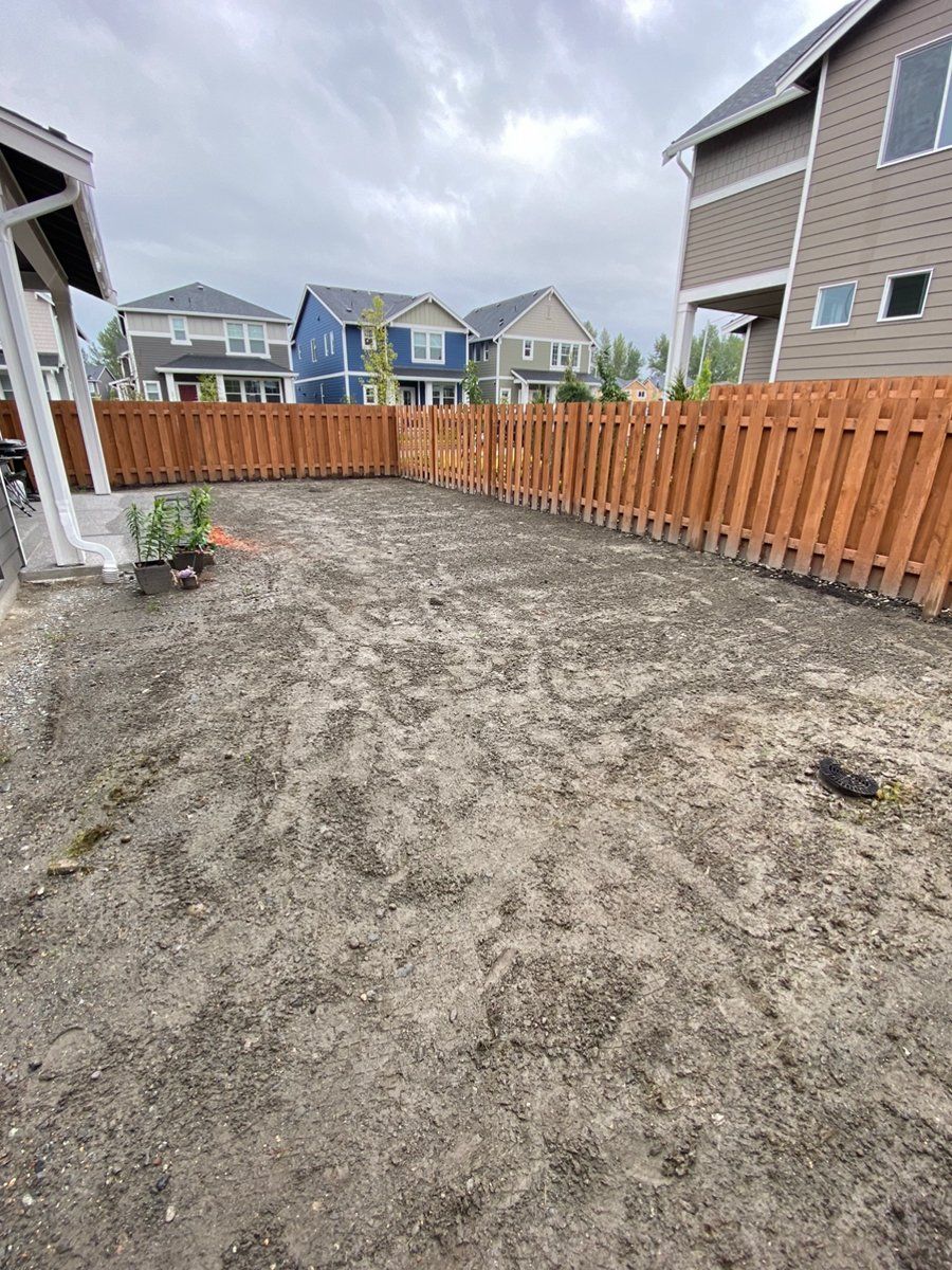 There is a wooden fence in the backyard of a house.