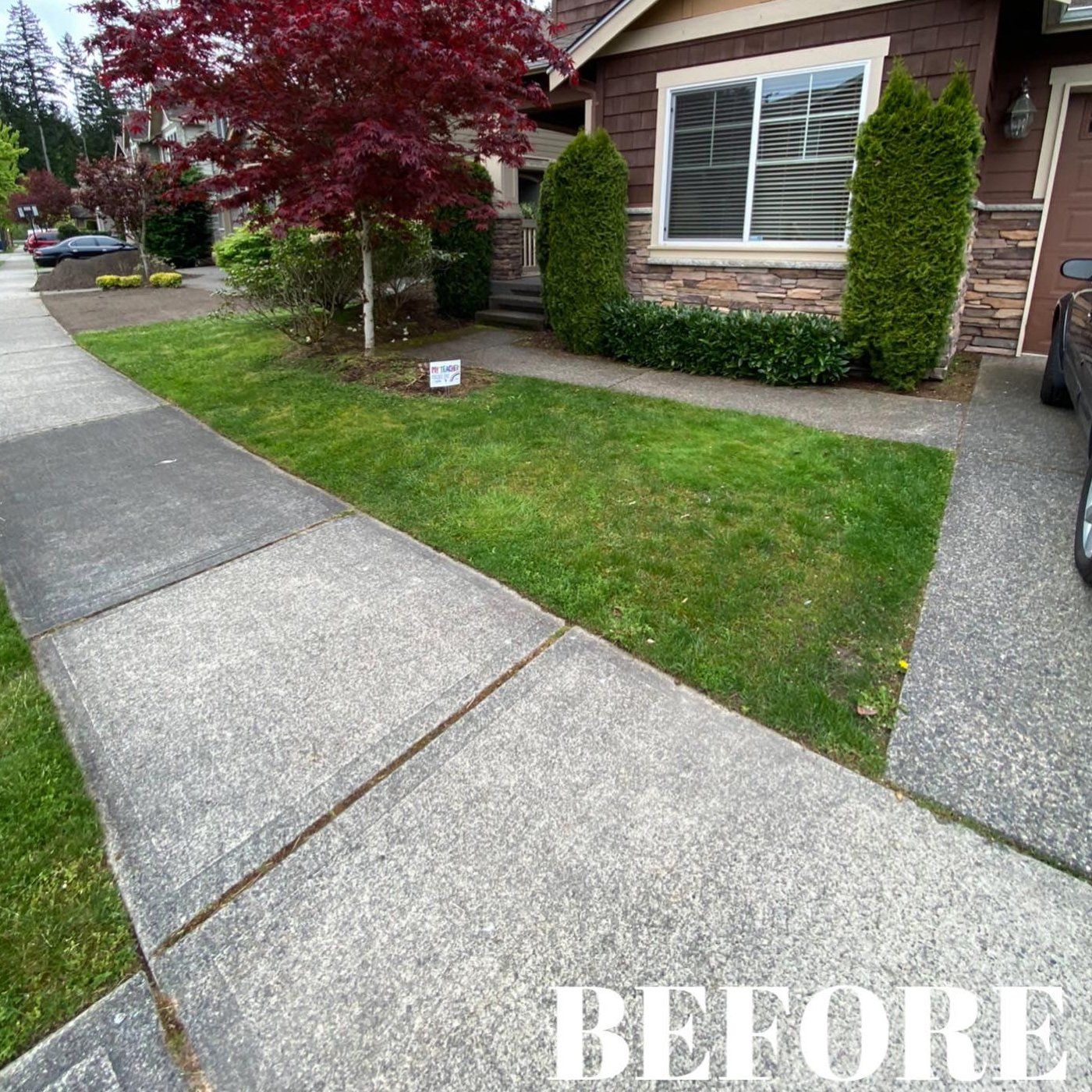 A before picture of a house with a lush green lawn