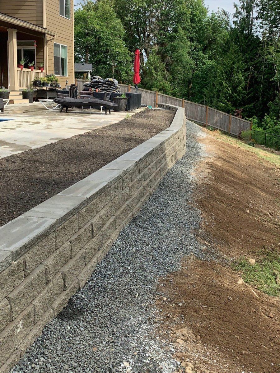A brick wall is being built in the backyard of a house.