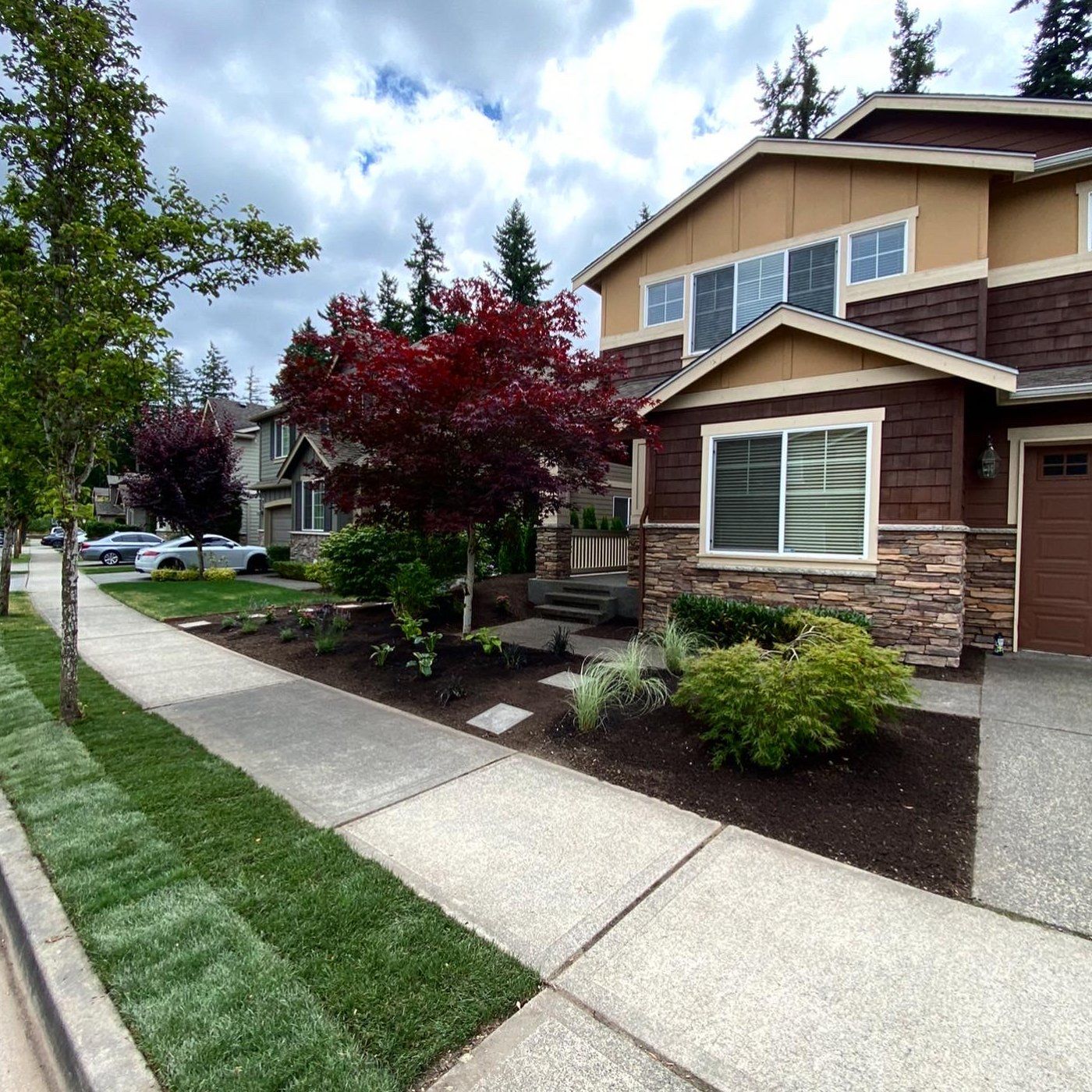 A house with a brown garage door is on a residential street