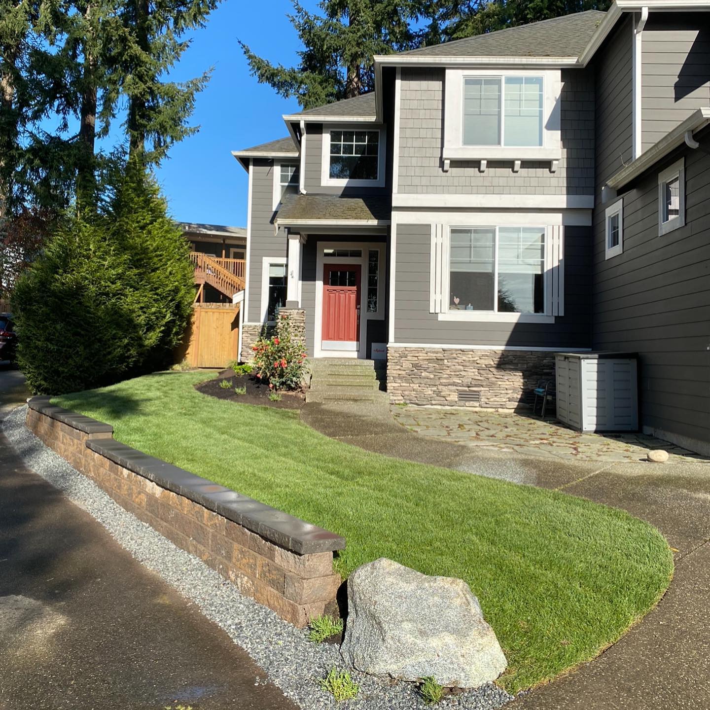 A house with a red door and a lush green lawn