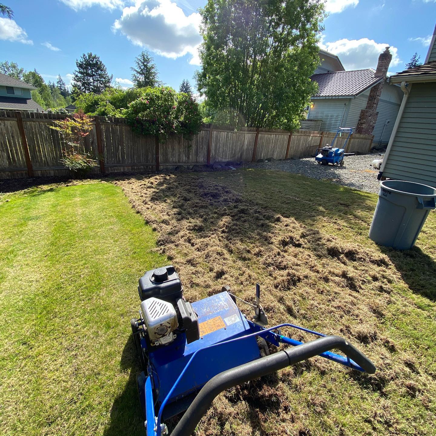 A blue lawn mower is sitting on top of a lush green lawn.