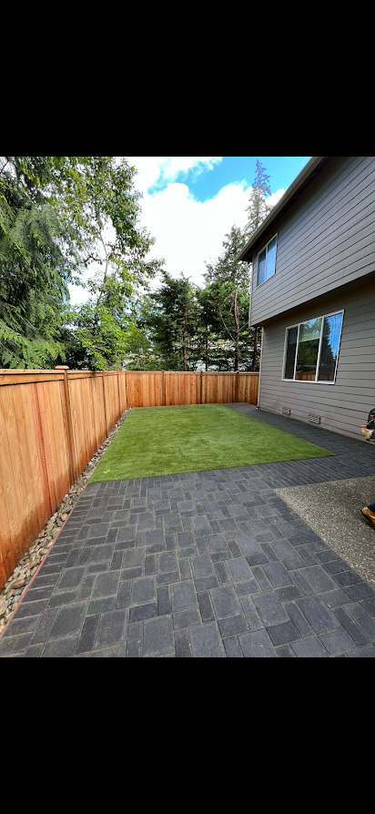 A house with a fence and a patio in front of it.