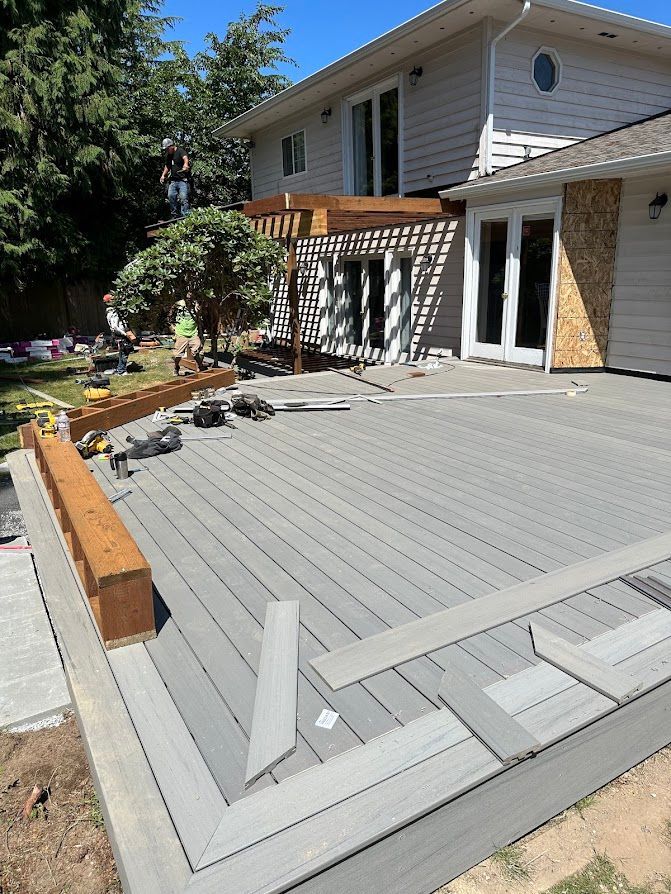 A gray deck is being built in front of a house.
