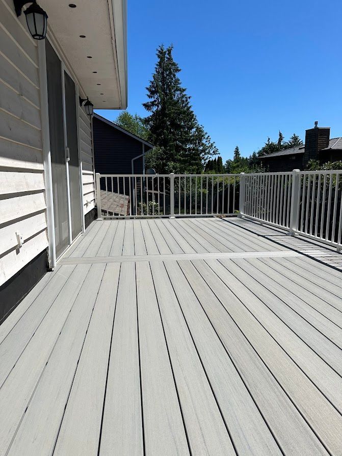 A large deck with a railing and a bench on it