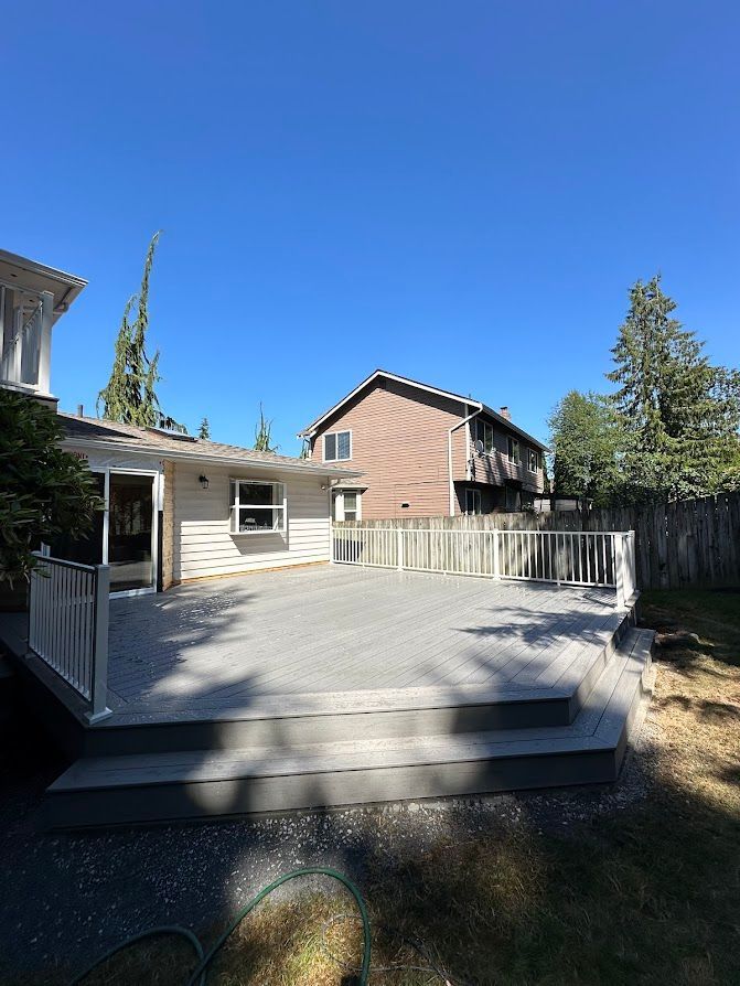 There is a large deck in the backyard of a house.