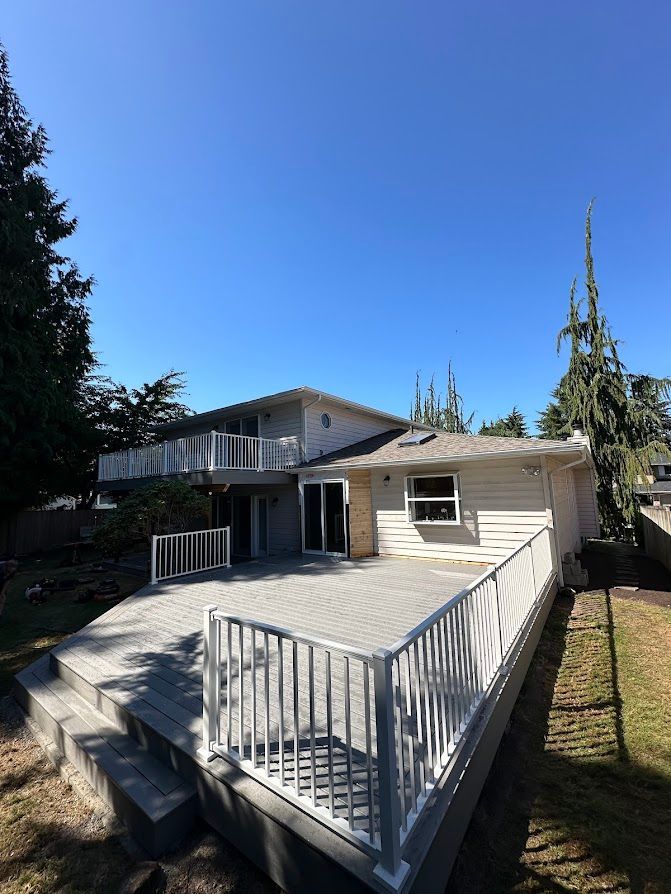 A white house with a large deck in front of it