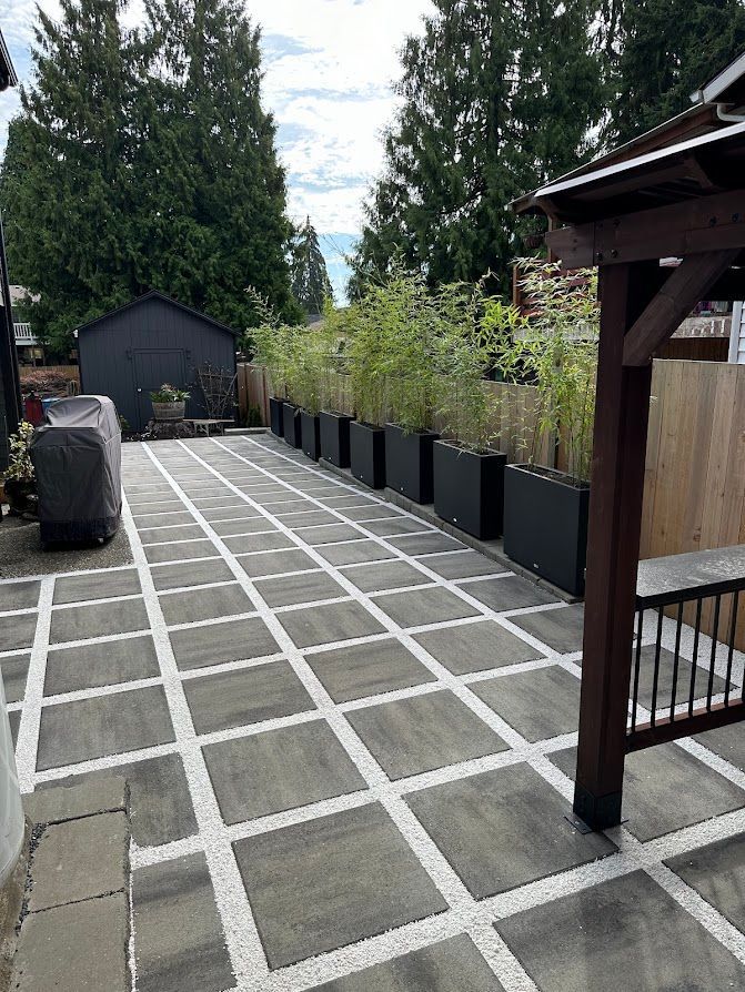 A patio with a lot of planters on it and a gazebo.