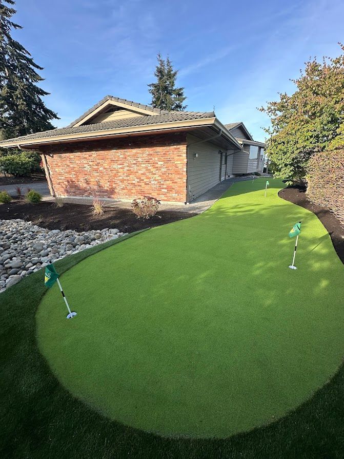 A house with a putting green in front of it.