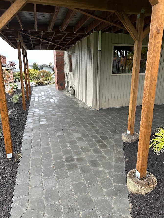 A walkway leading to a house with a wooden roof.
