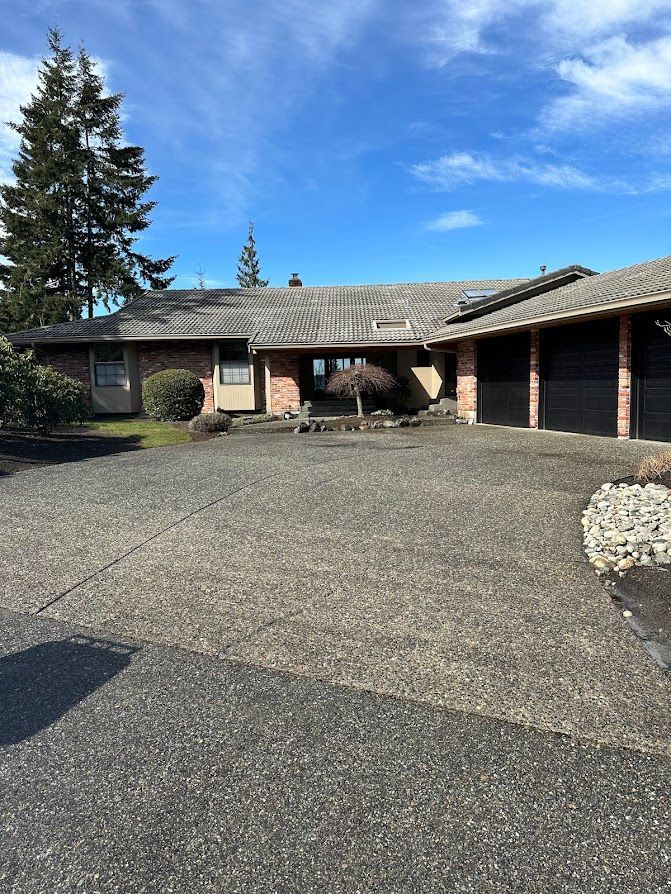 A large brick house with two garages and a driveway.
