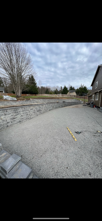 A large empty parking lot with a house in the background.