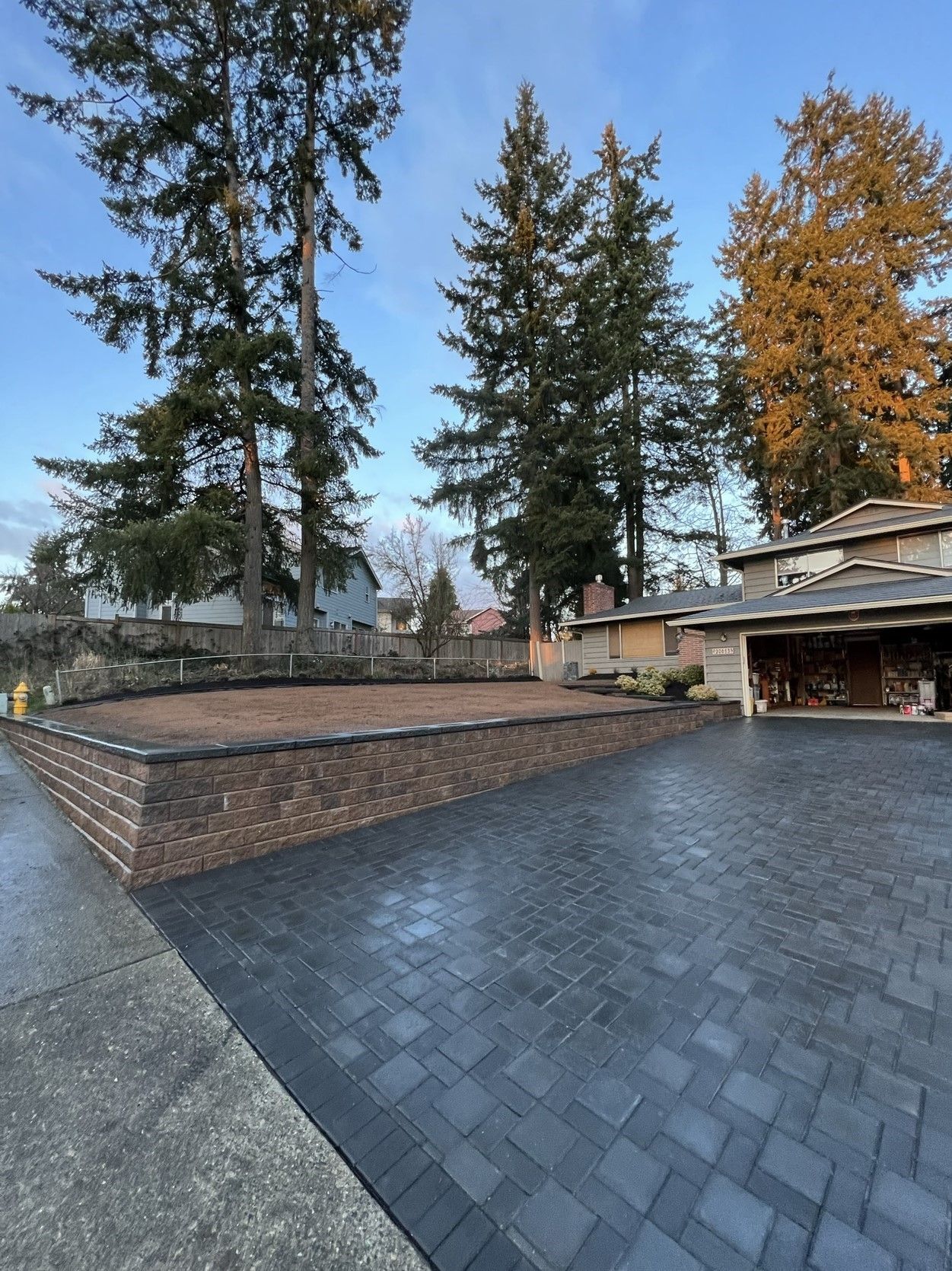 A driveway leading to a house with trees in the background