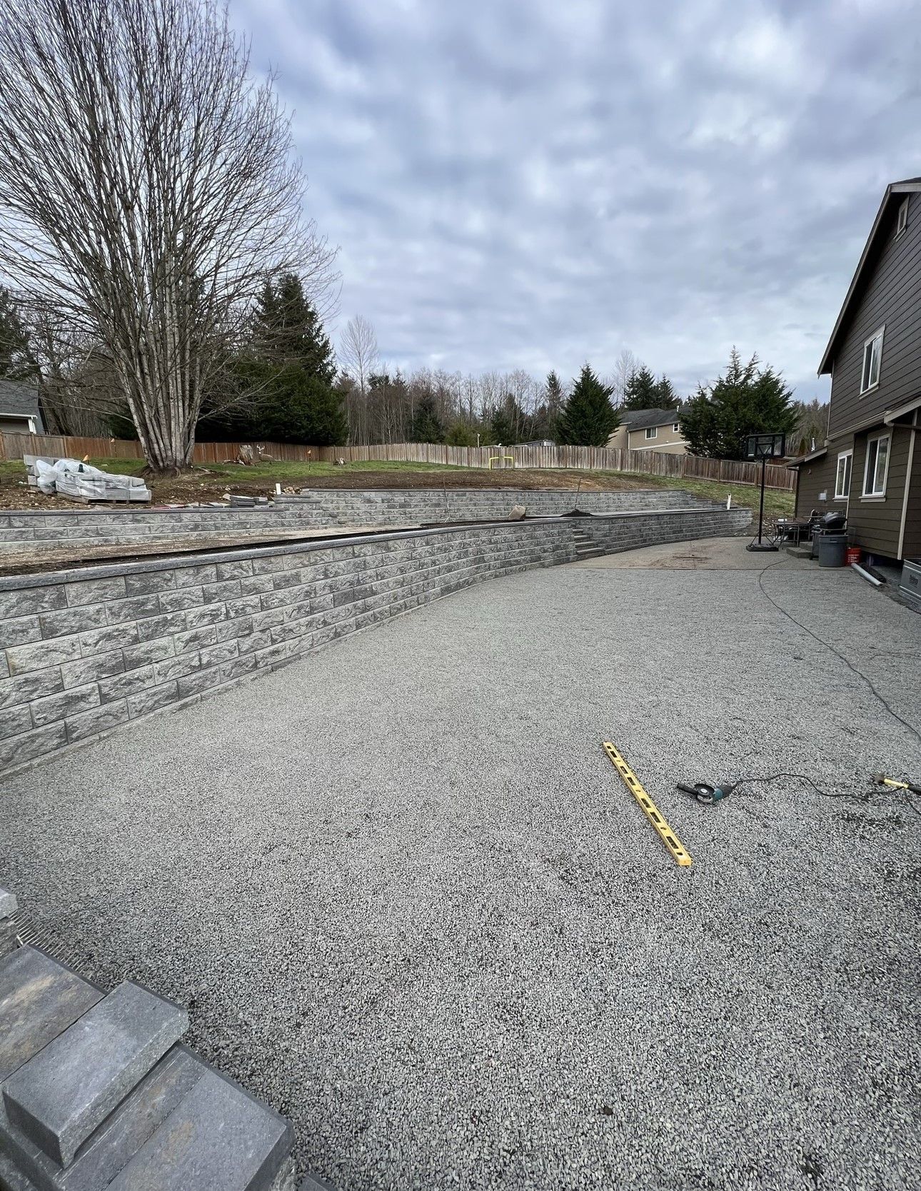 A gravel driveway is being built in front of a house.