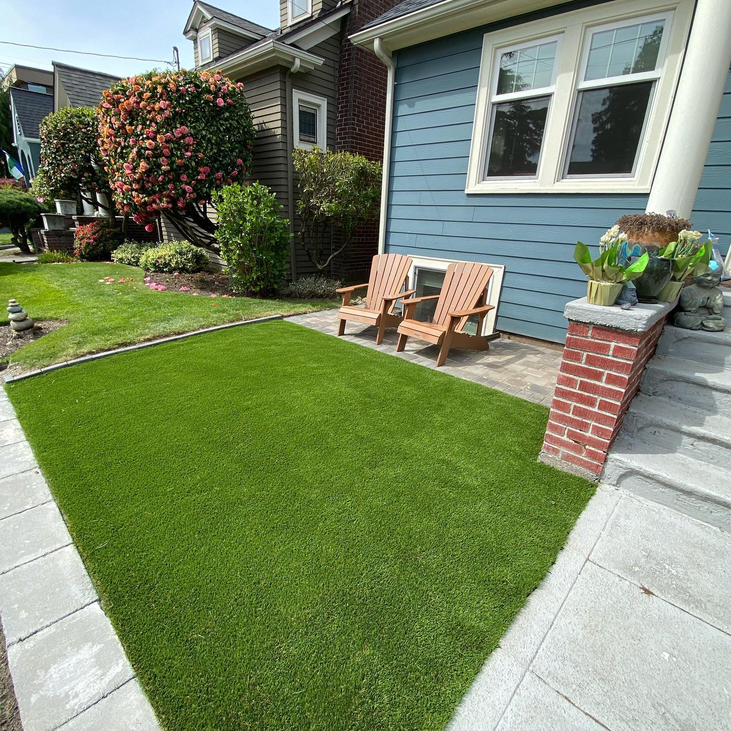 A house with a lawn and chairs in front of it.