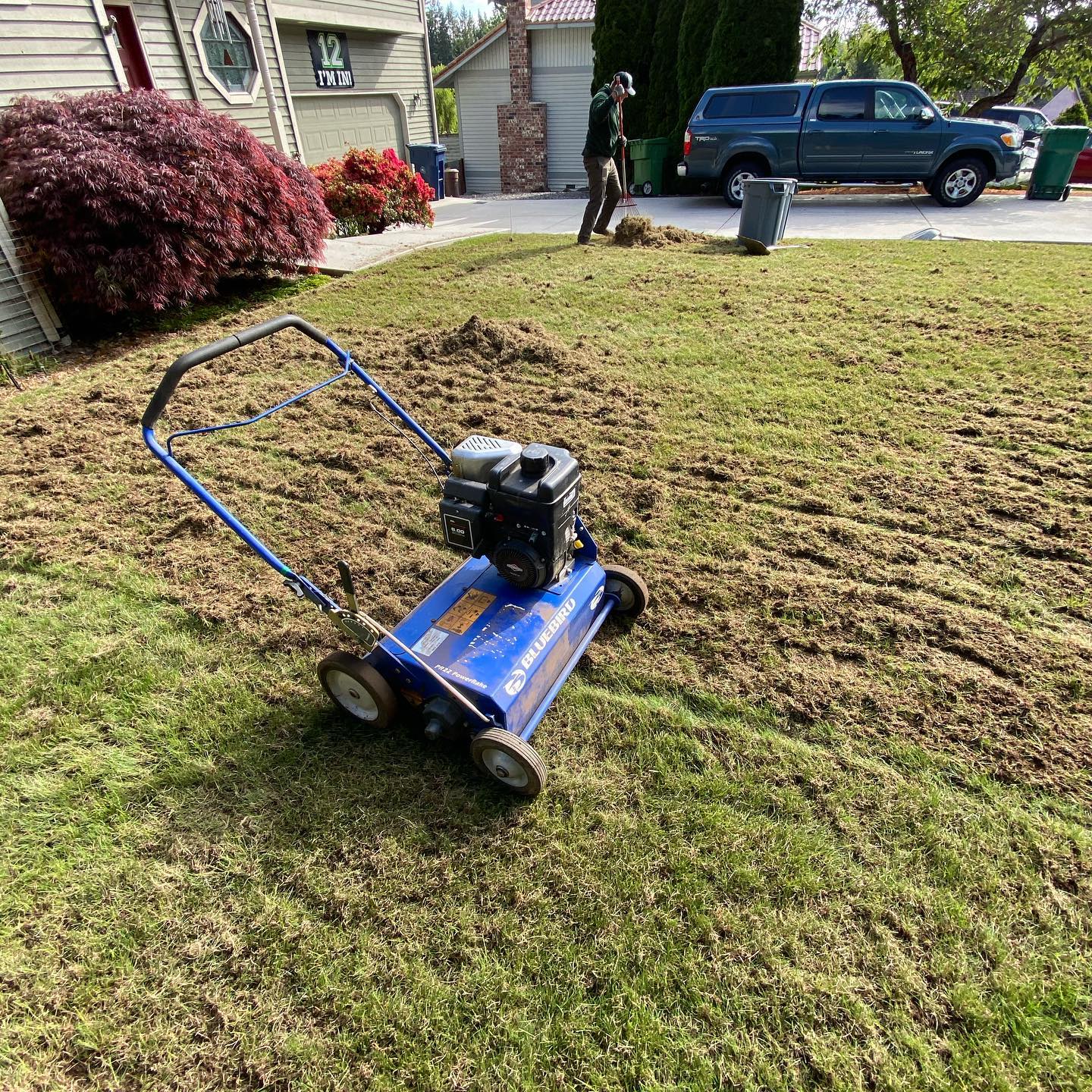 A blue lawn mower is sitting on top of a lush green lawn.