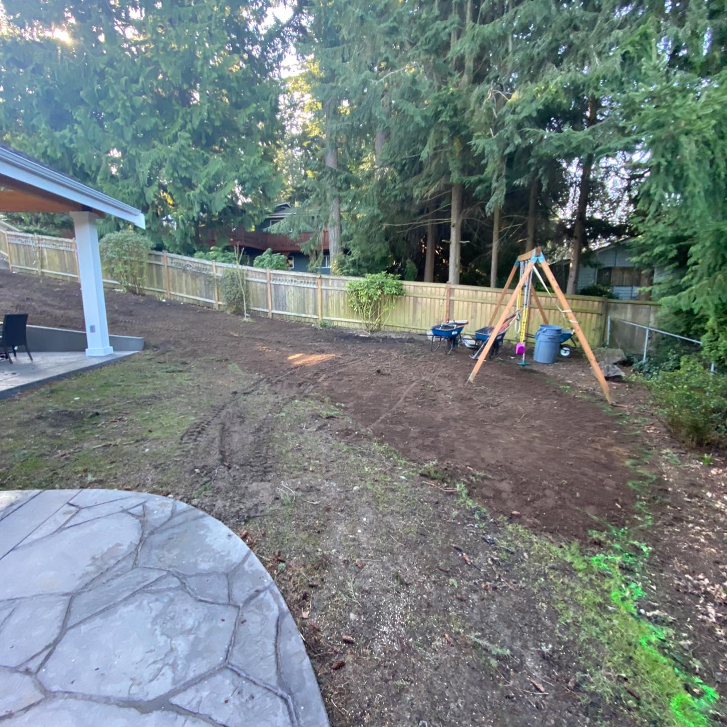 A backyard with a swing set and a fence