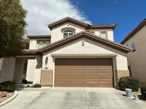 Two-story beige house with brown trim and garage door, blue sky.
