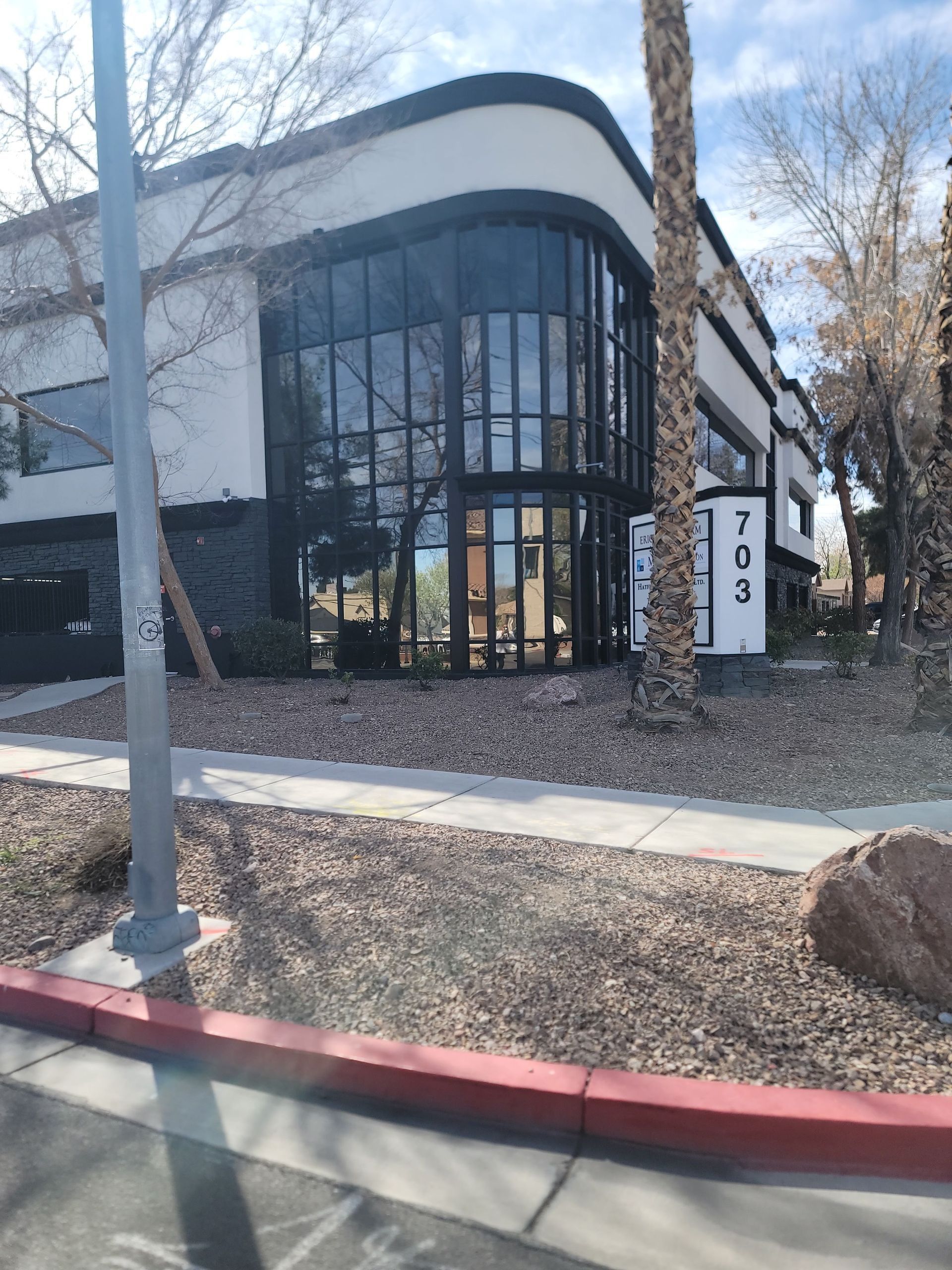 Office building with large glass windows and the number 703 displayed.