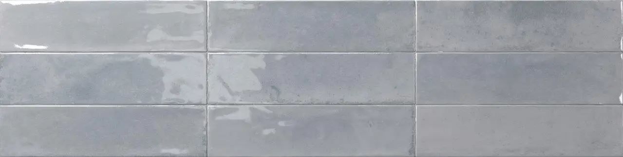 Close-up of a light gray tiled wall with horizontal seams and subtle texture
