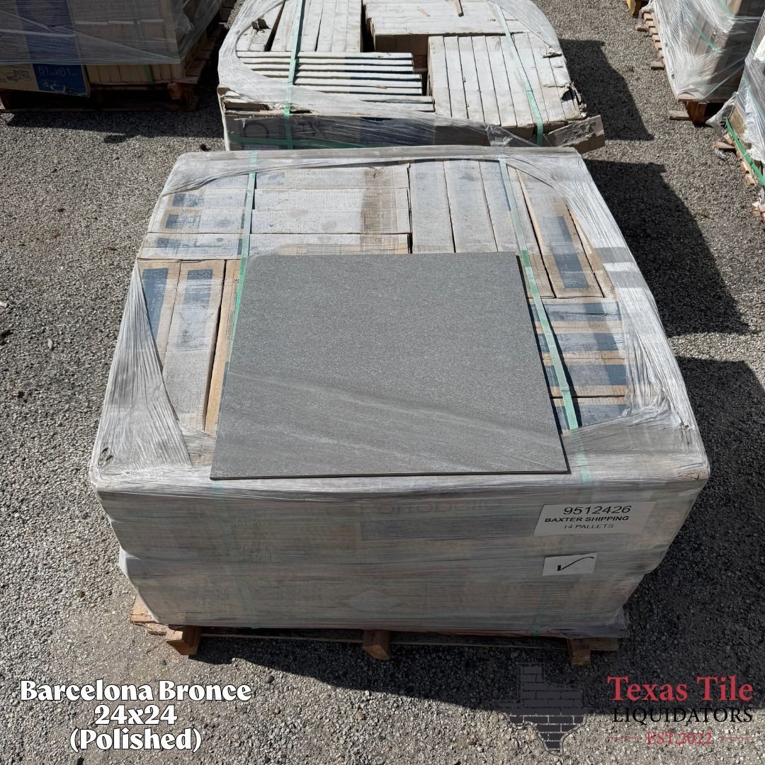 Wrapped stone slabs stacked on pallets outdoors in a gravel lot