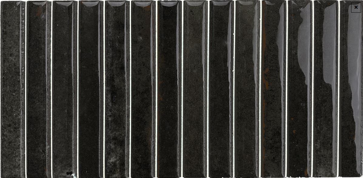 Row of dark vertical metal slats with a worn, textured surface and narrow light gaps between them